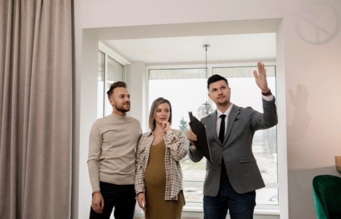 couple discussing estate agent fees with property professional