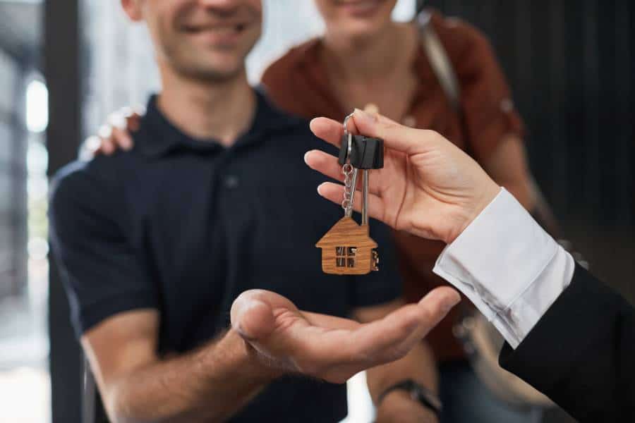 Couple receiving keys to rented property - A terraced property with a to let sign - Couple using a laptop in their rented property - Assets For Life