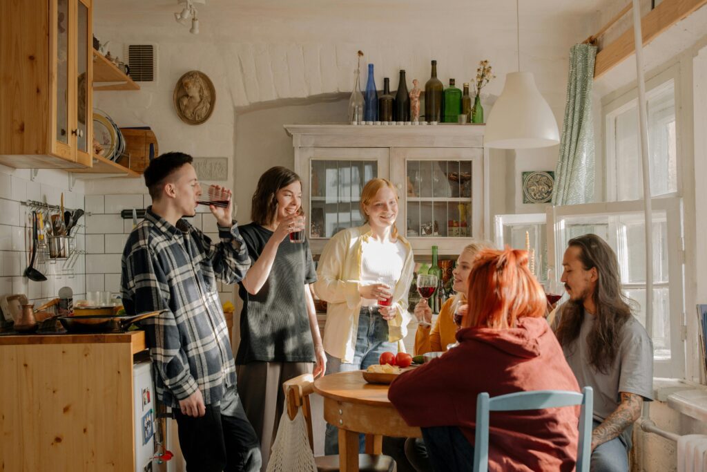 Person using a laptop to browse houseshare websites, with images of shared living spaces on the screen.