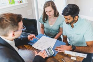 Couple discussing shared ownership houses with an agent - Assets For Life