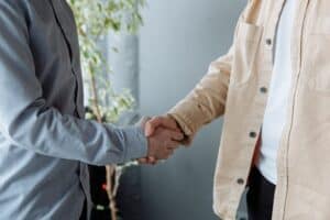 Two people shaking hands after buying a business - Assets For Life