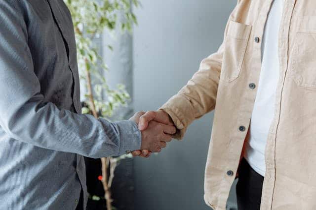 Two people shaking hands after buying a business - Assets For Life