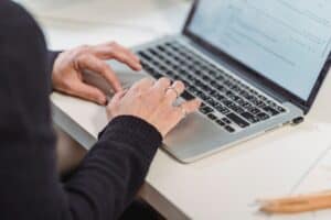 Deal sourcing and packaging expert looking through compliance documents on a laptop - Assets For Life